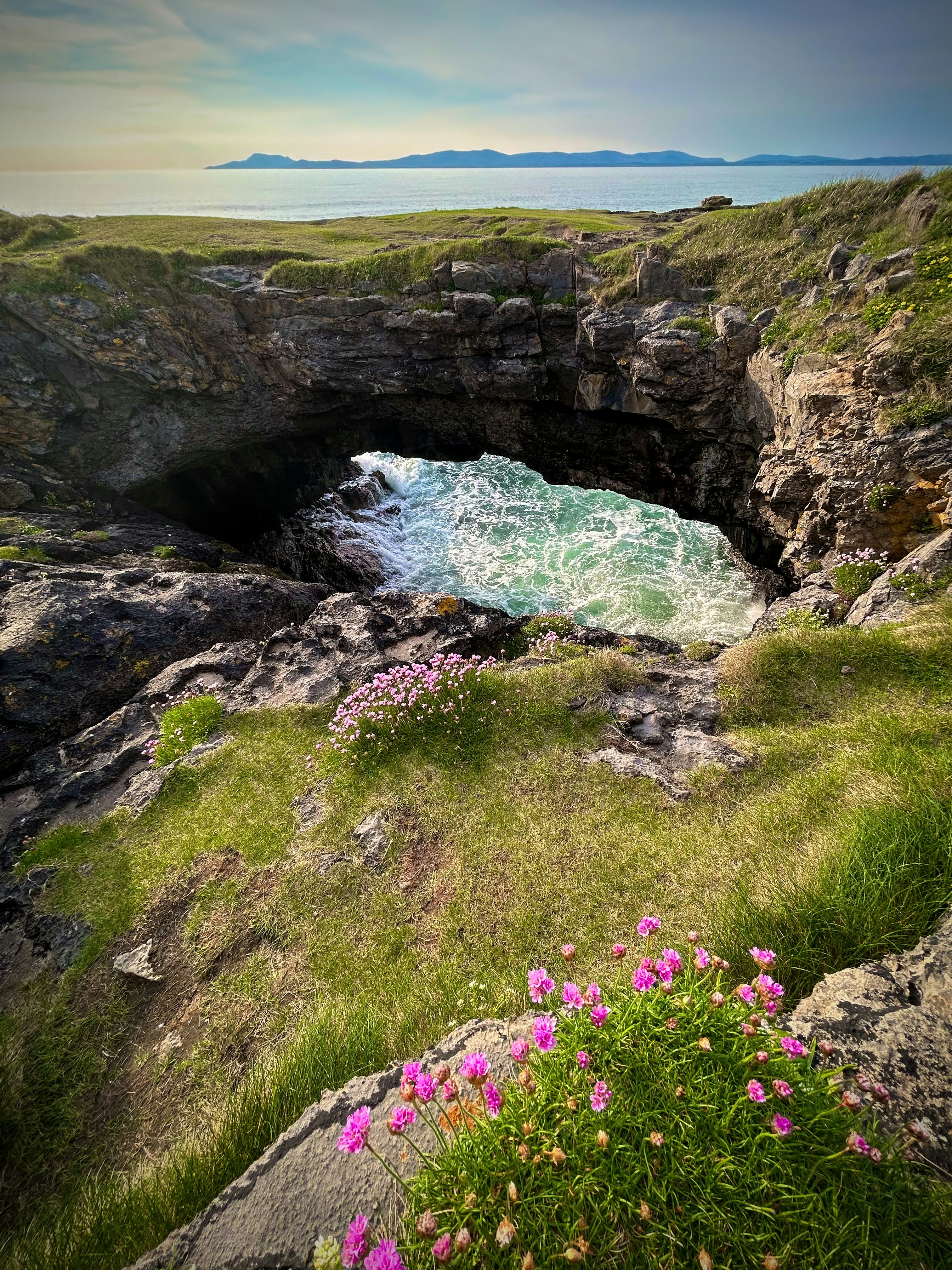Le onde dell'oceano si infrangono attraverso un'apertura rocciosa.
