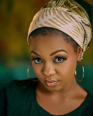 Beautiful woman with a head wrap stares intensely.