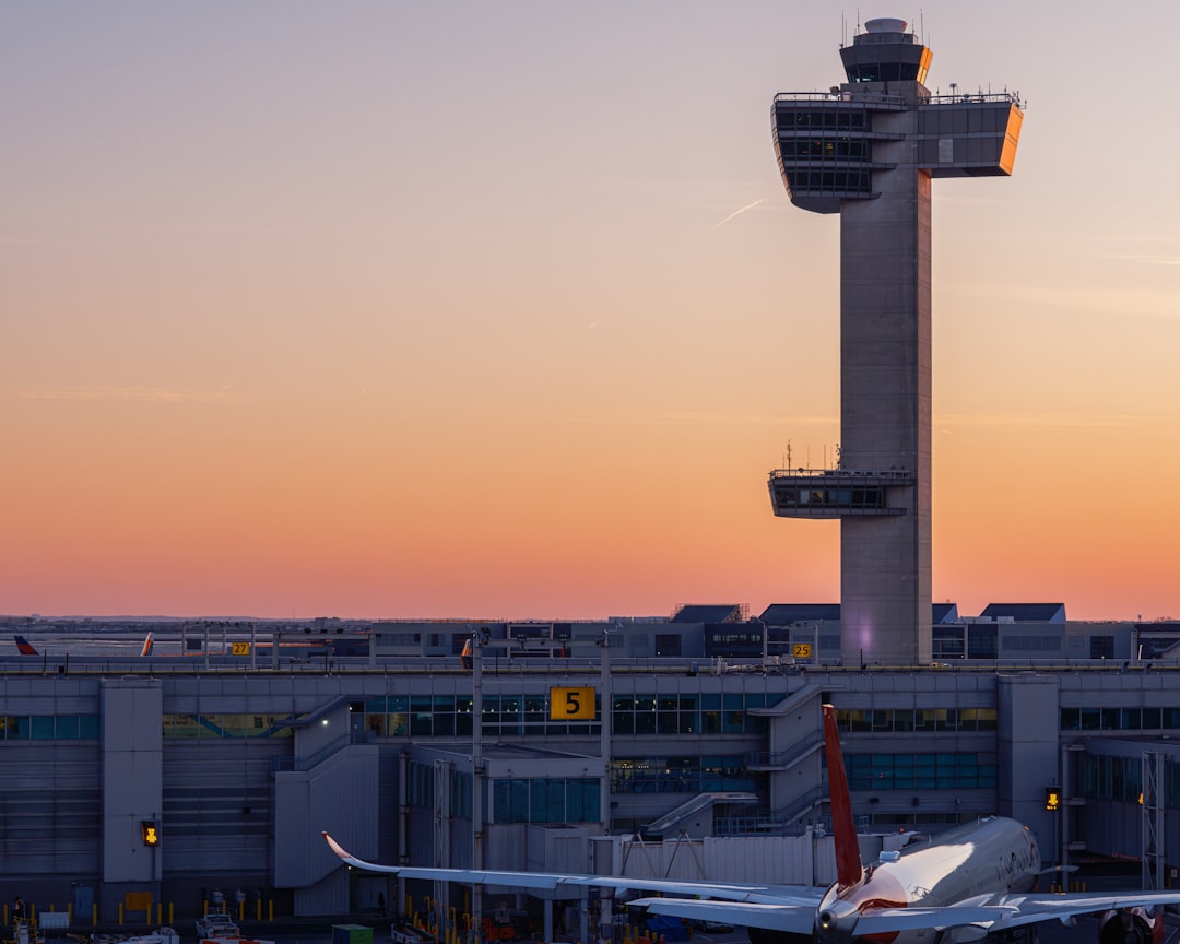 Airport control tower with a sunset in the background.
