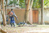 A person uses a leaf blower in a yard.