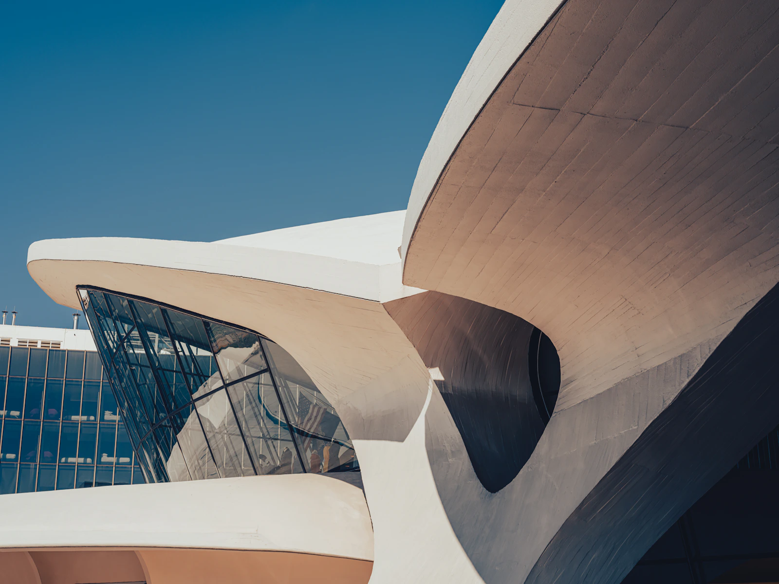 Curved modern airport terminal beneath a clear blue sky