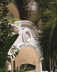 Hotel la palma's entrance is framed by foliage.