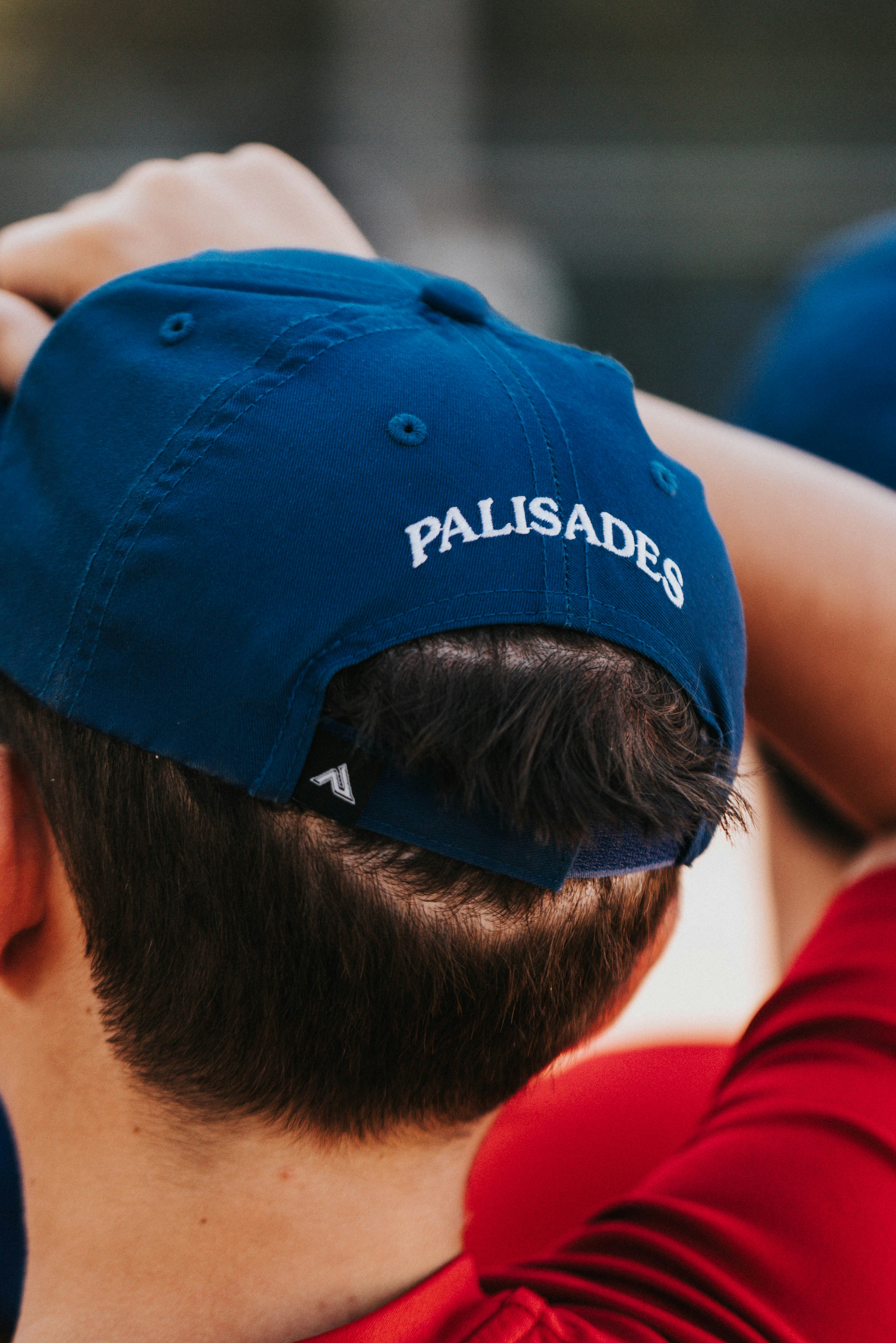 A person wears a blue hat that says "palisades."