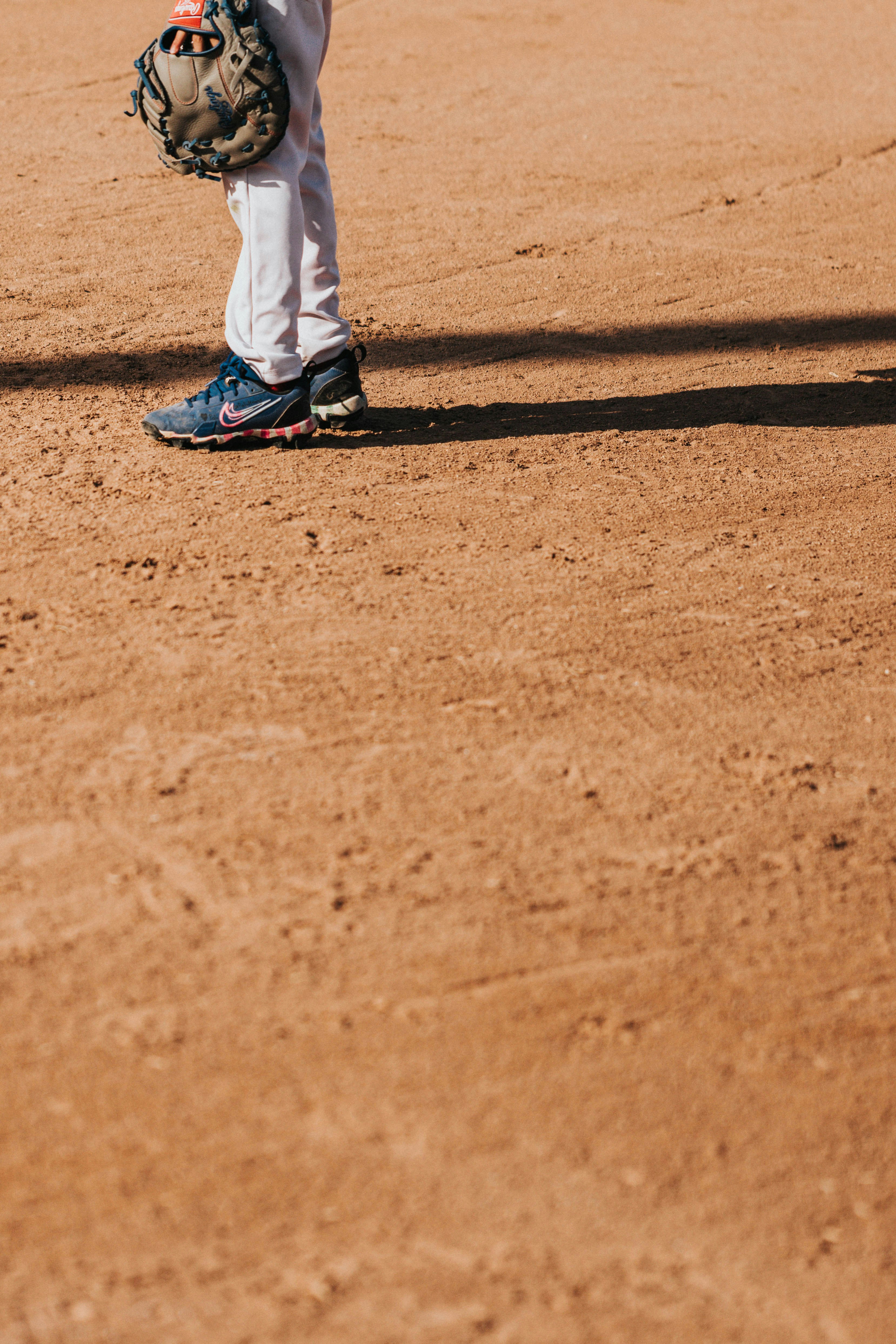 A baseball player stands ready on the dirt field.