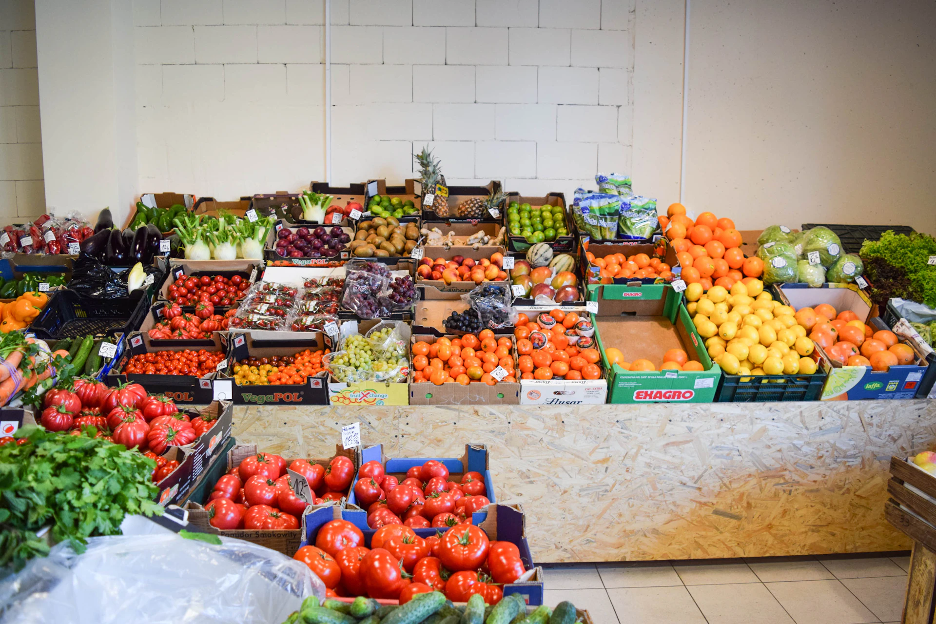Fresh fruits and vegetables are neatly displayed on shelves.