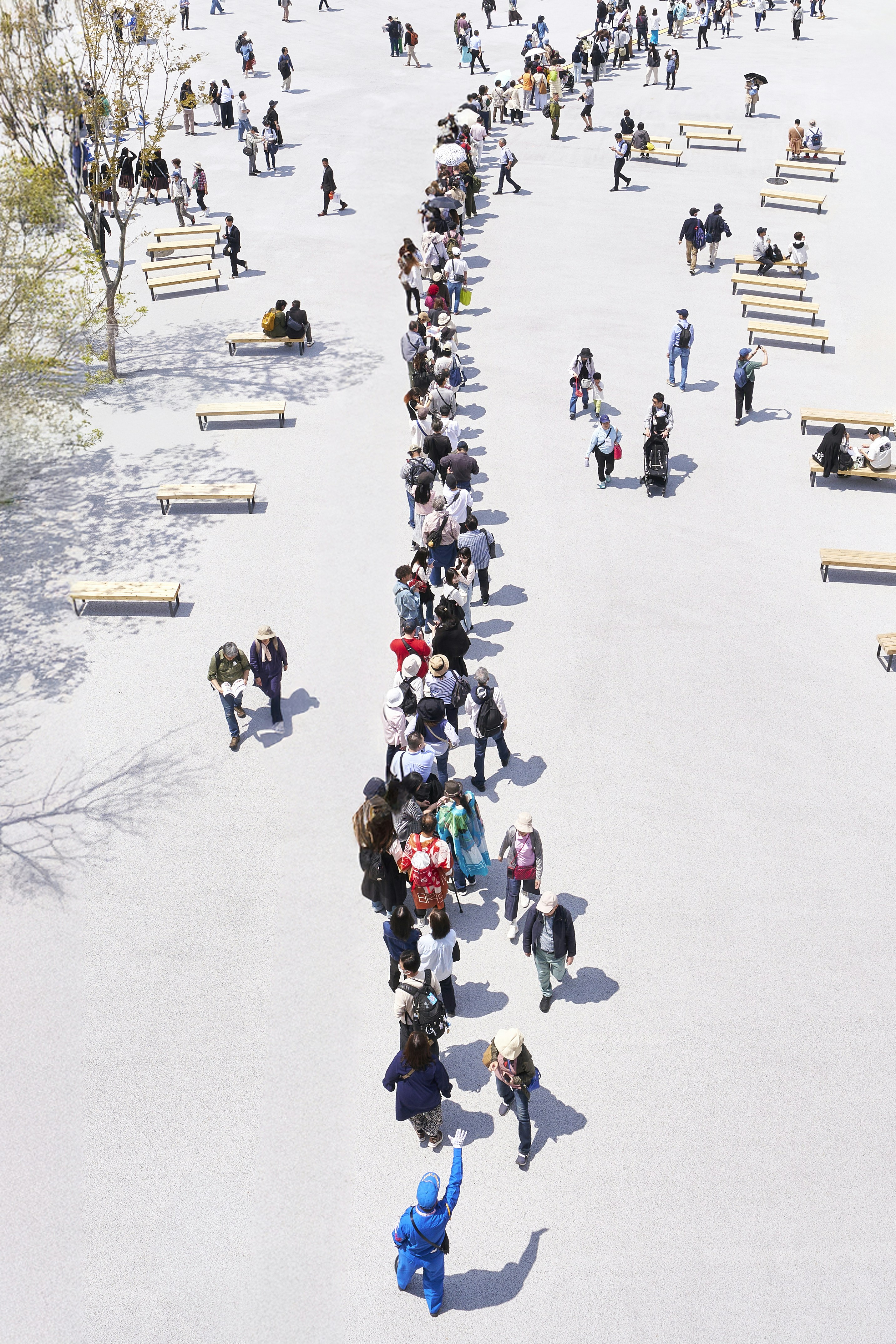 A long line of people are waiting outdoors.