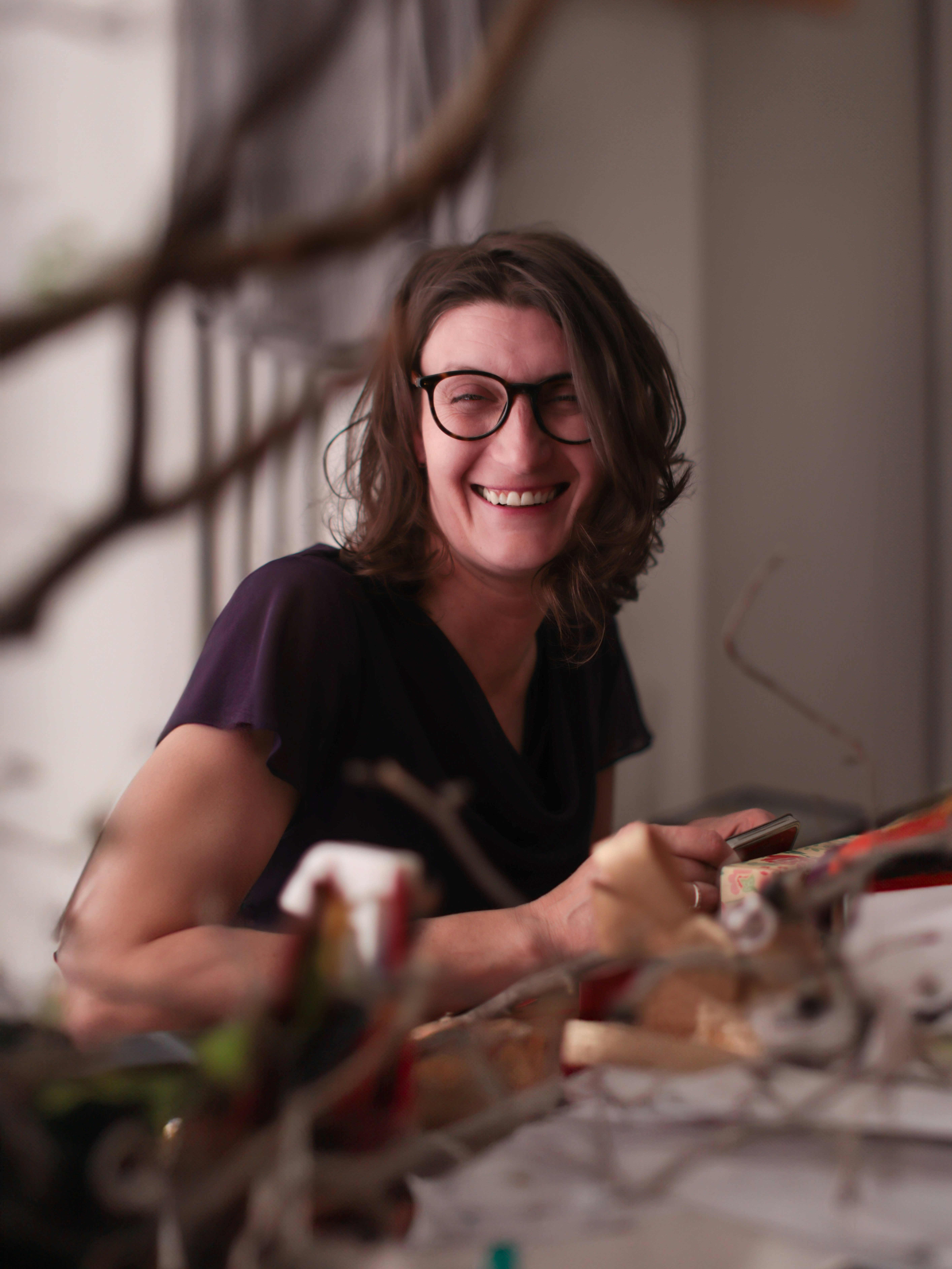 Mulher sorri enquanto olha para algo.