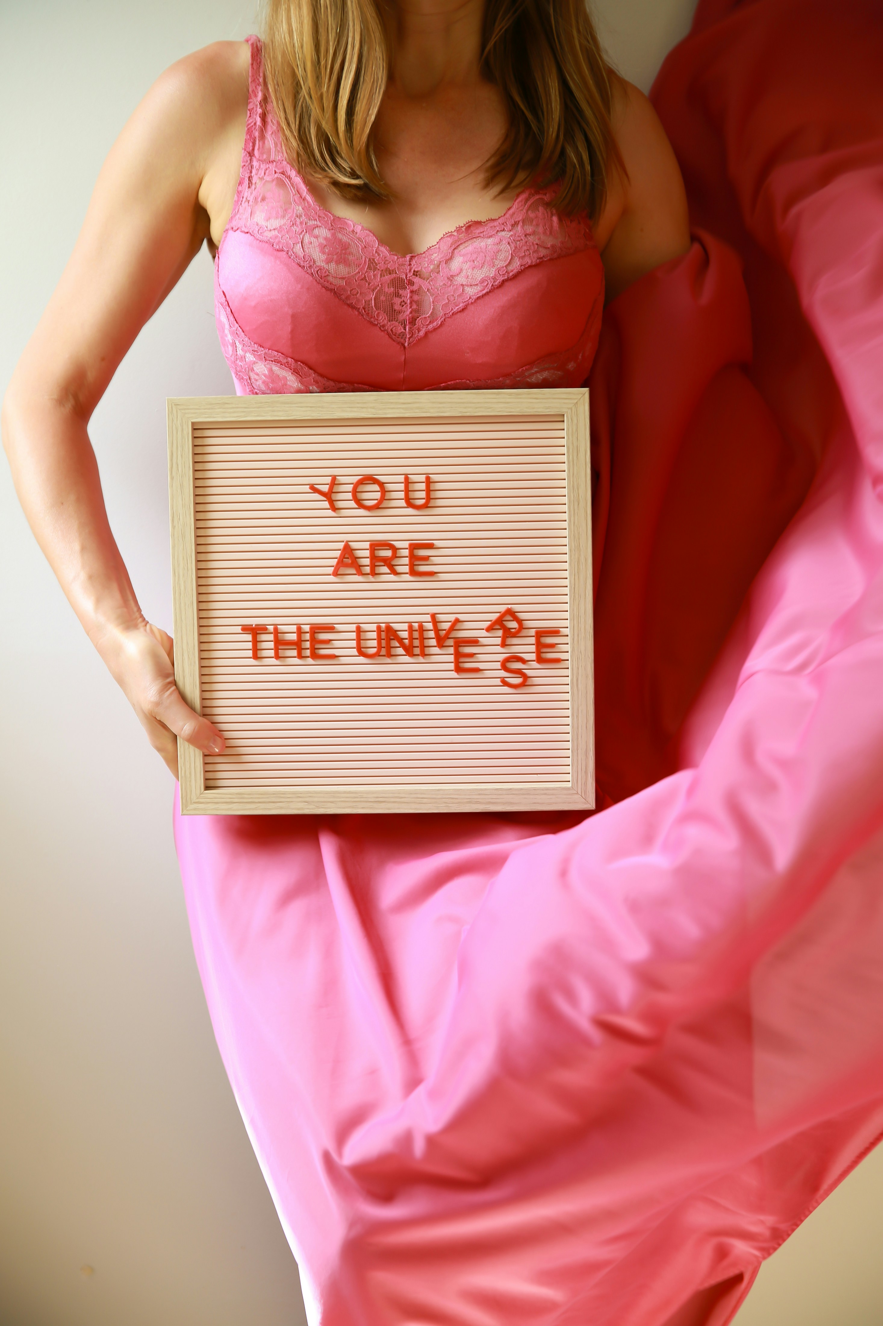 Uma mulher segura uma placa dizendo "você é o universo".
