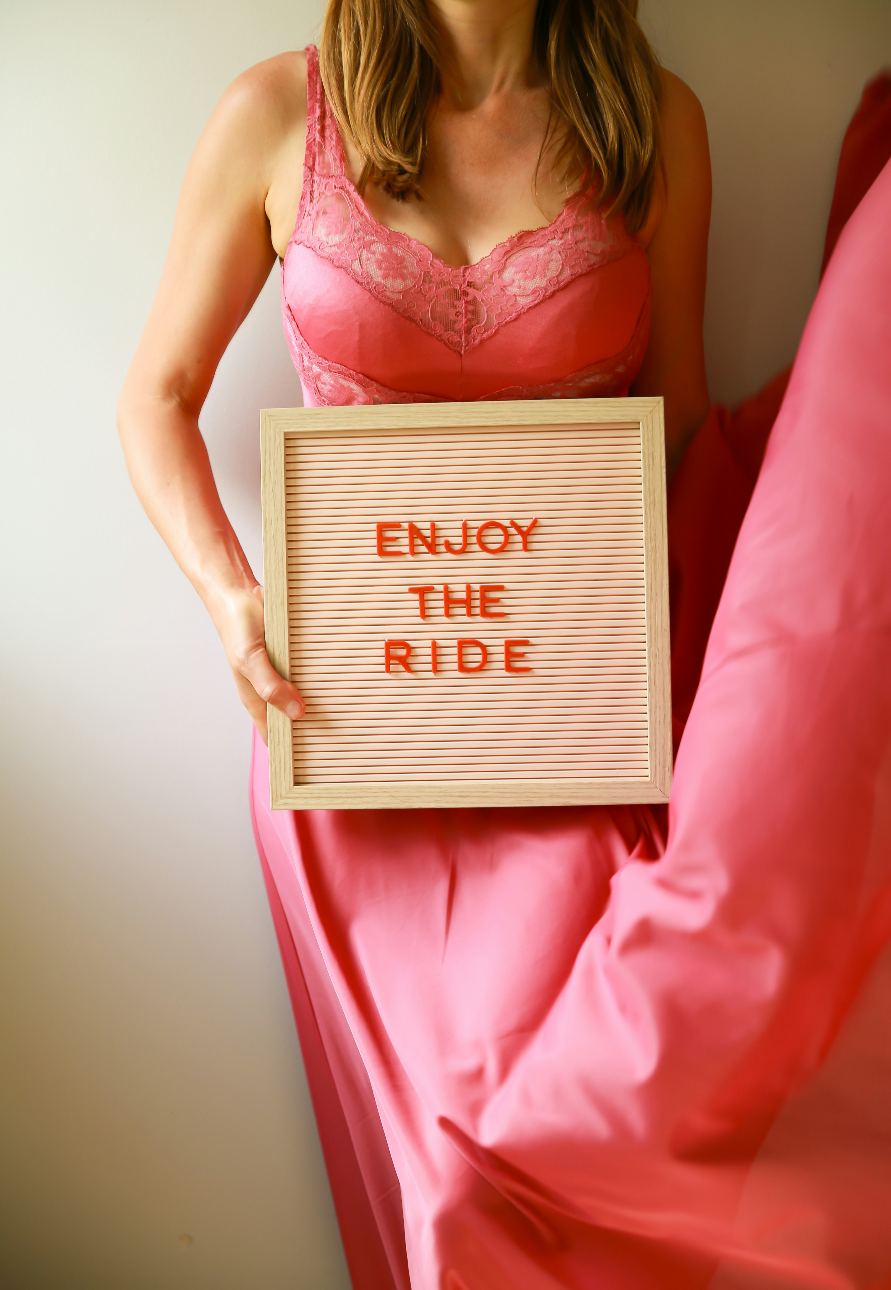 Woman in pink holding a sign saying 