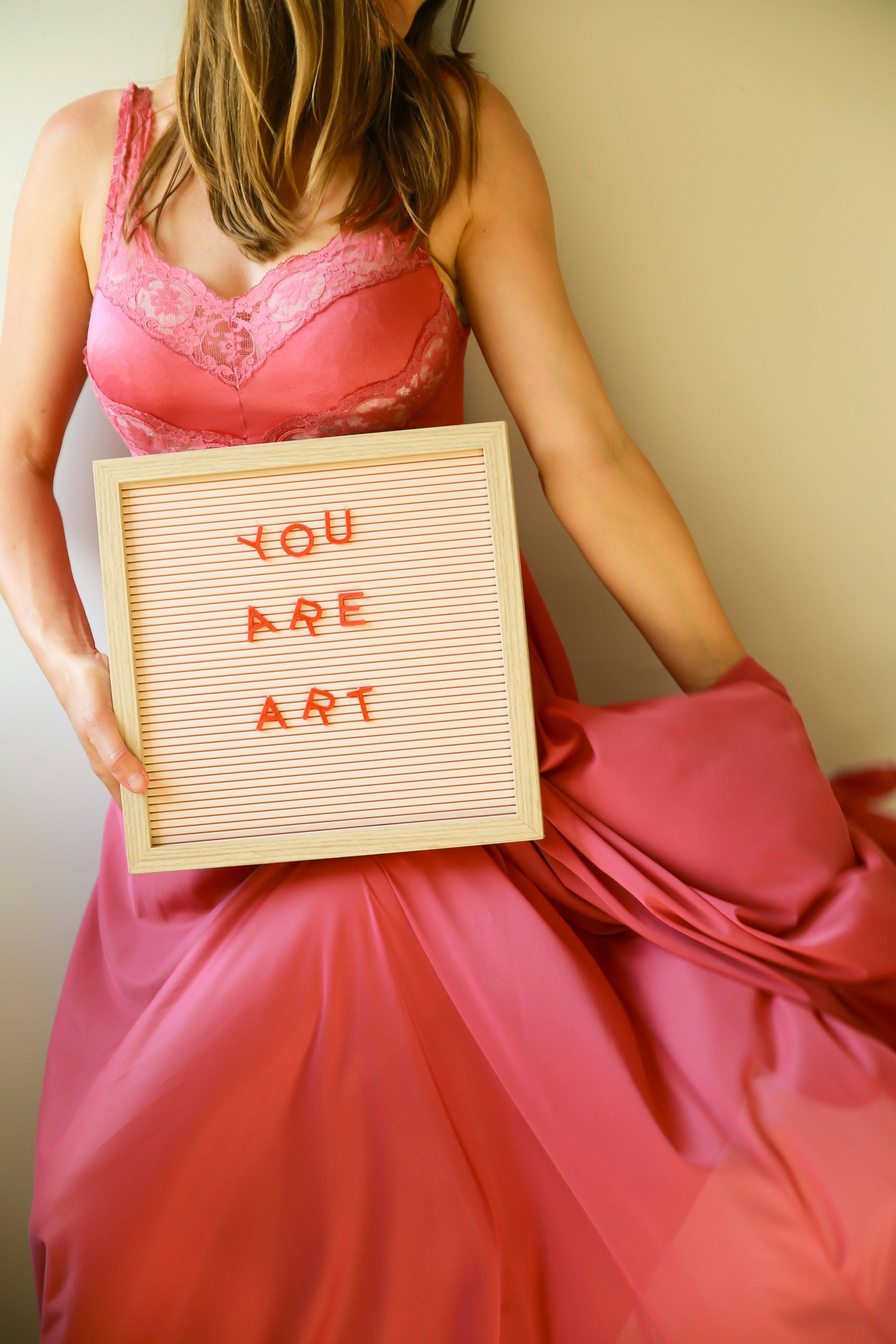 A woman holds a sign saying "you are art."