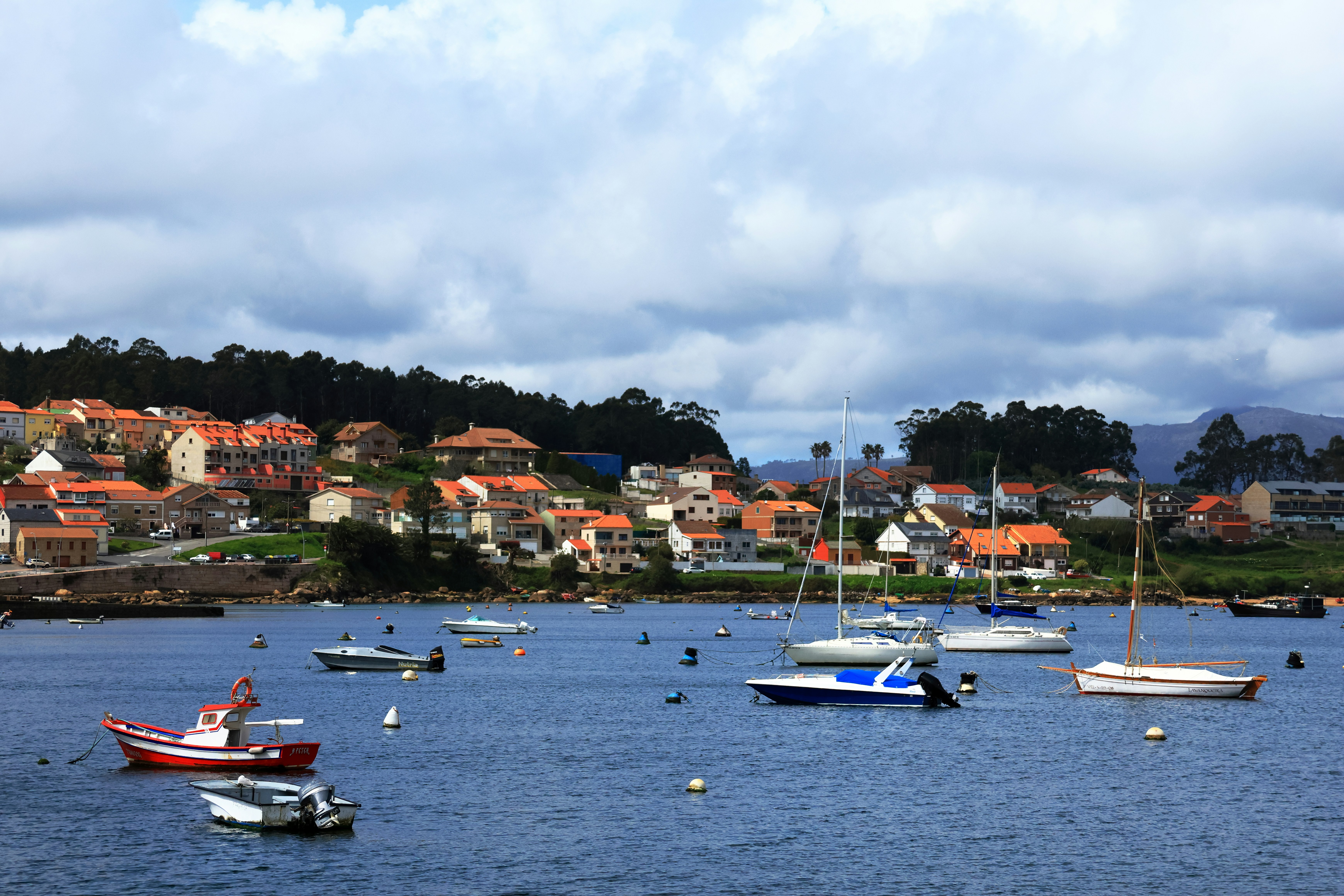 Barcos flutuam no porto de uma cidade costeira.