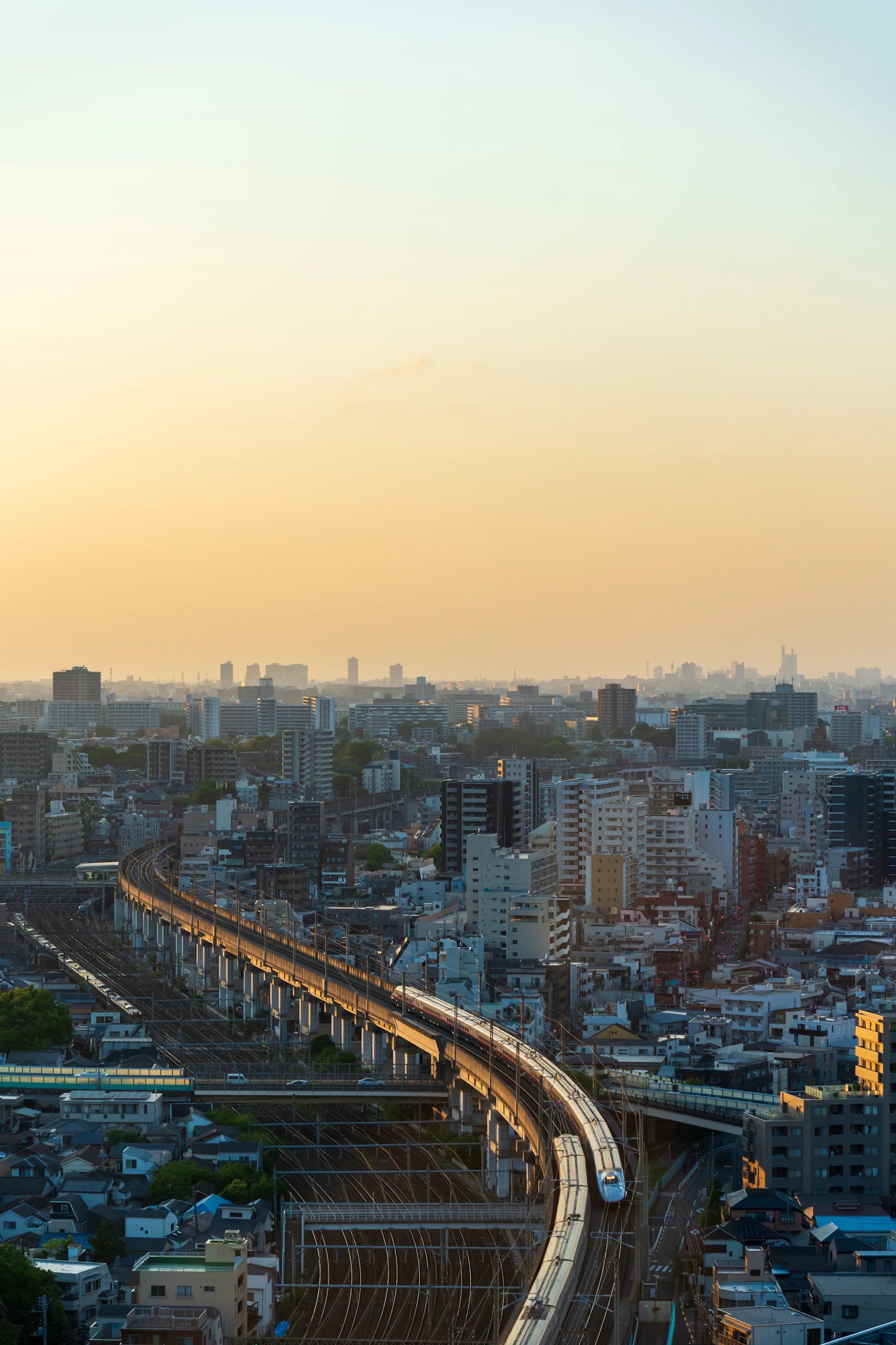 A train travels through the city at sunset.