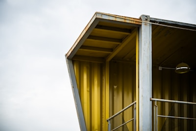 A modern structure's corner under a cloudy sky.