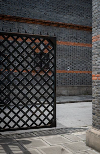 A black gate opens into a brick street.