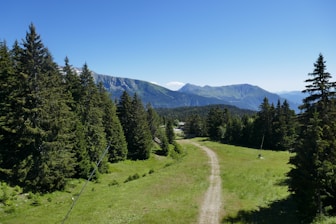 A winding path leads through green mountain scenery.