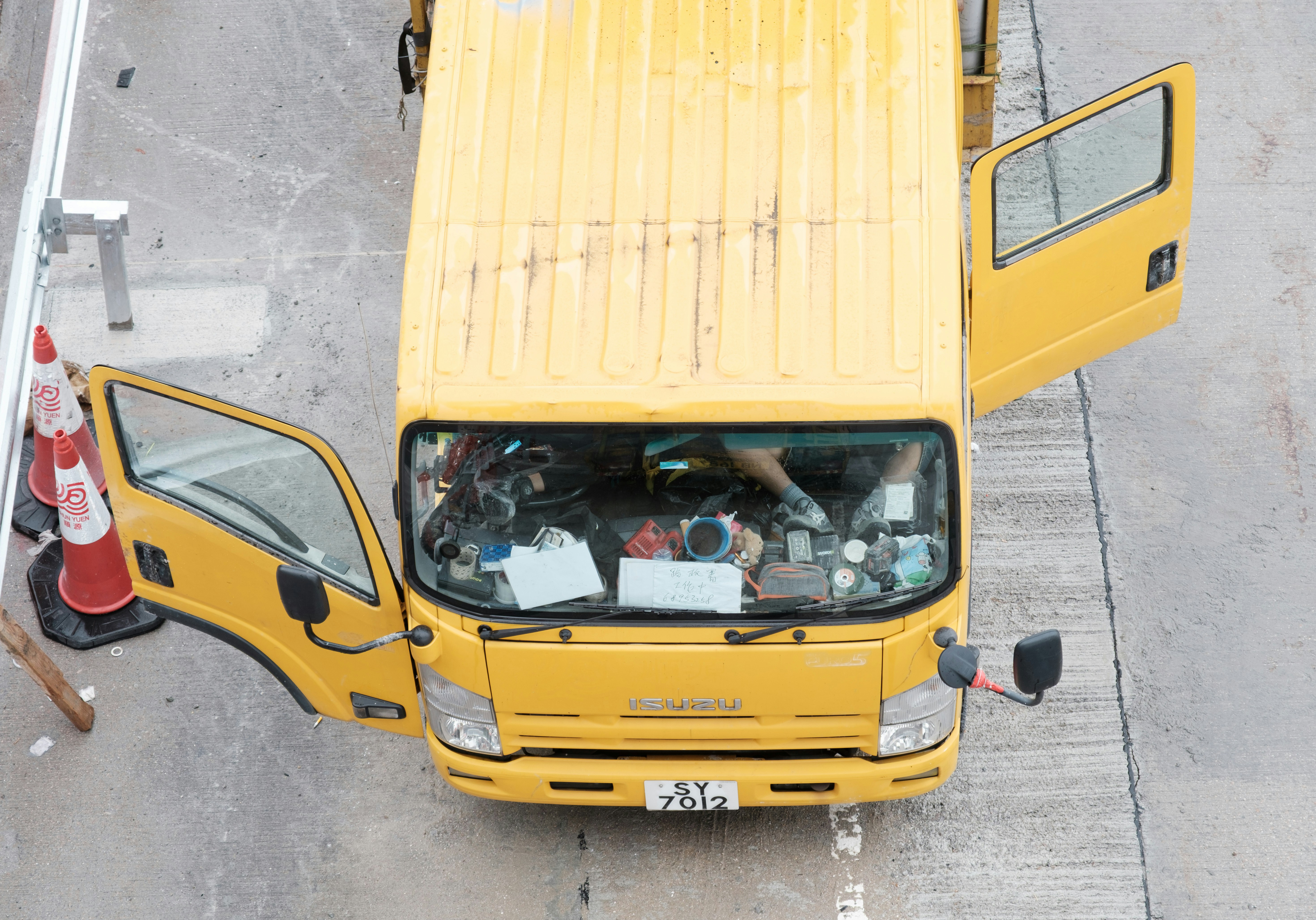 Yellow truck with open doors is parked.