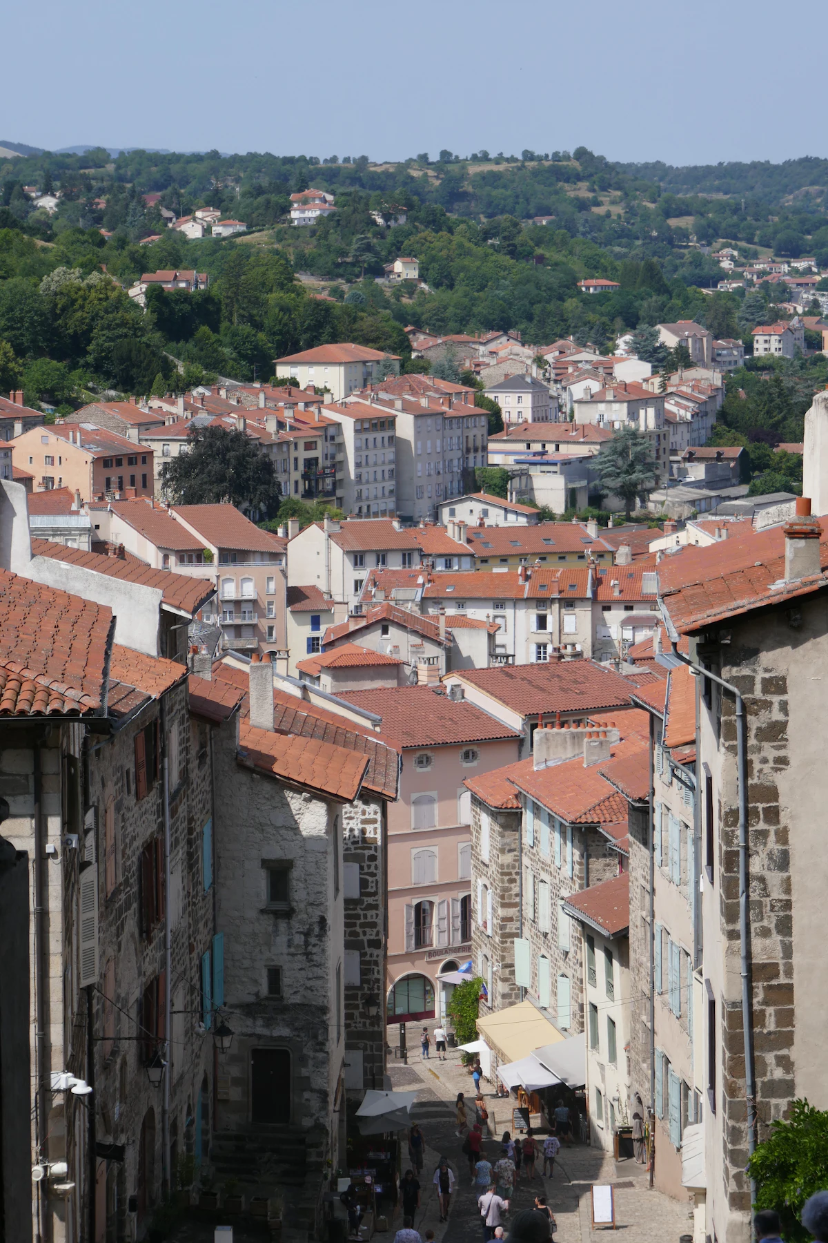 A steep street of stone houses running down through Le Puy-en-Velay