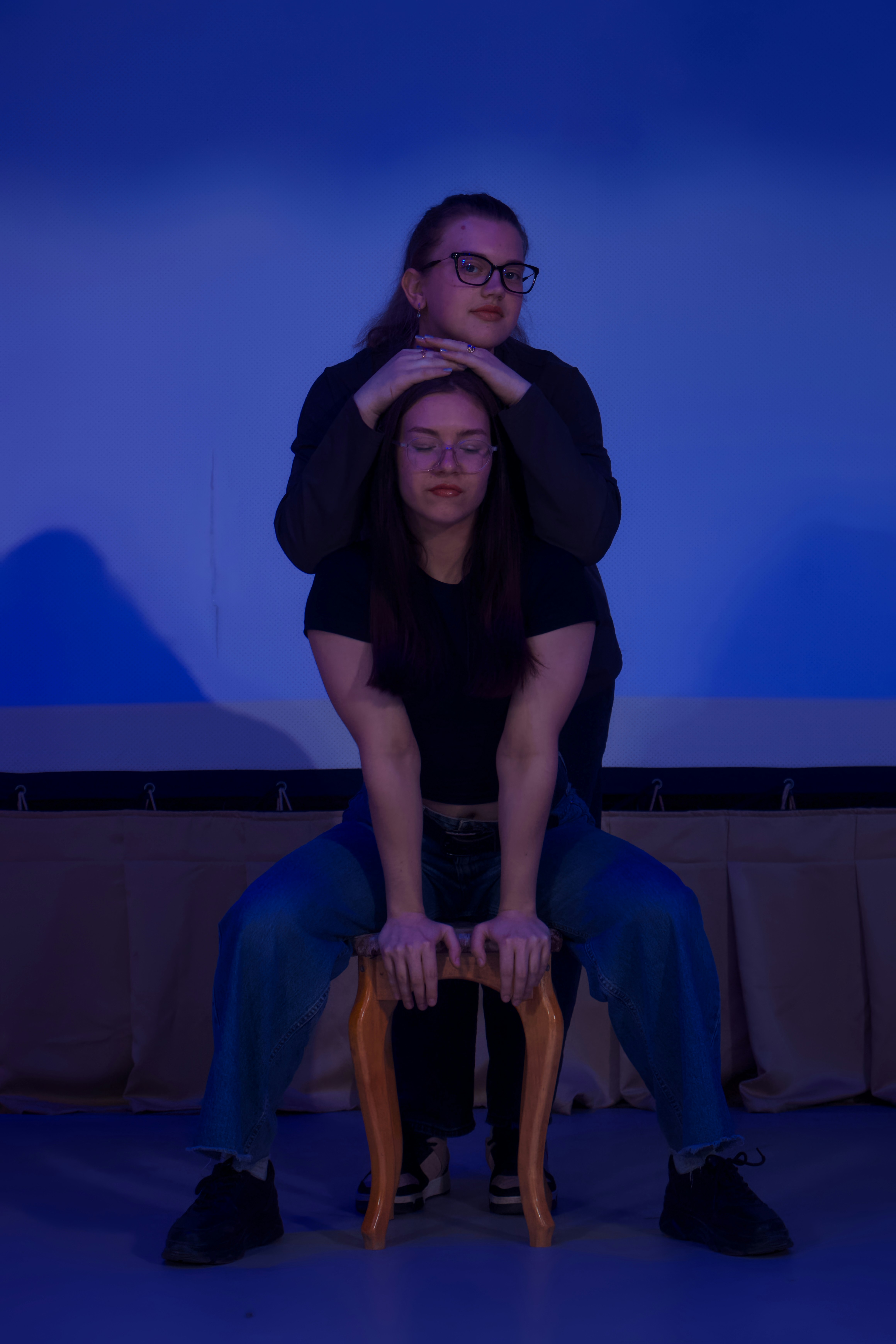 Couple posing on a chair under blue lighting