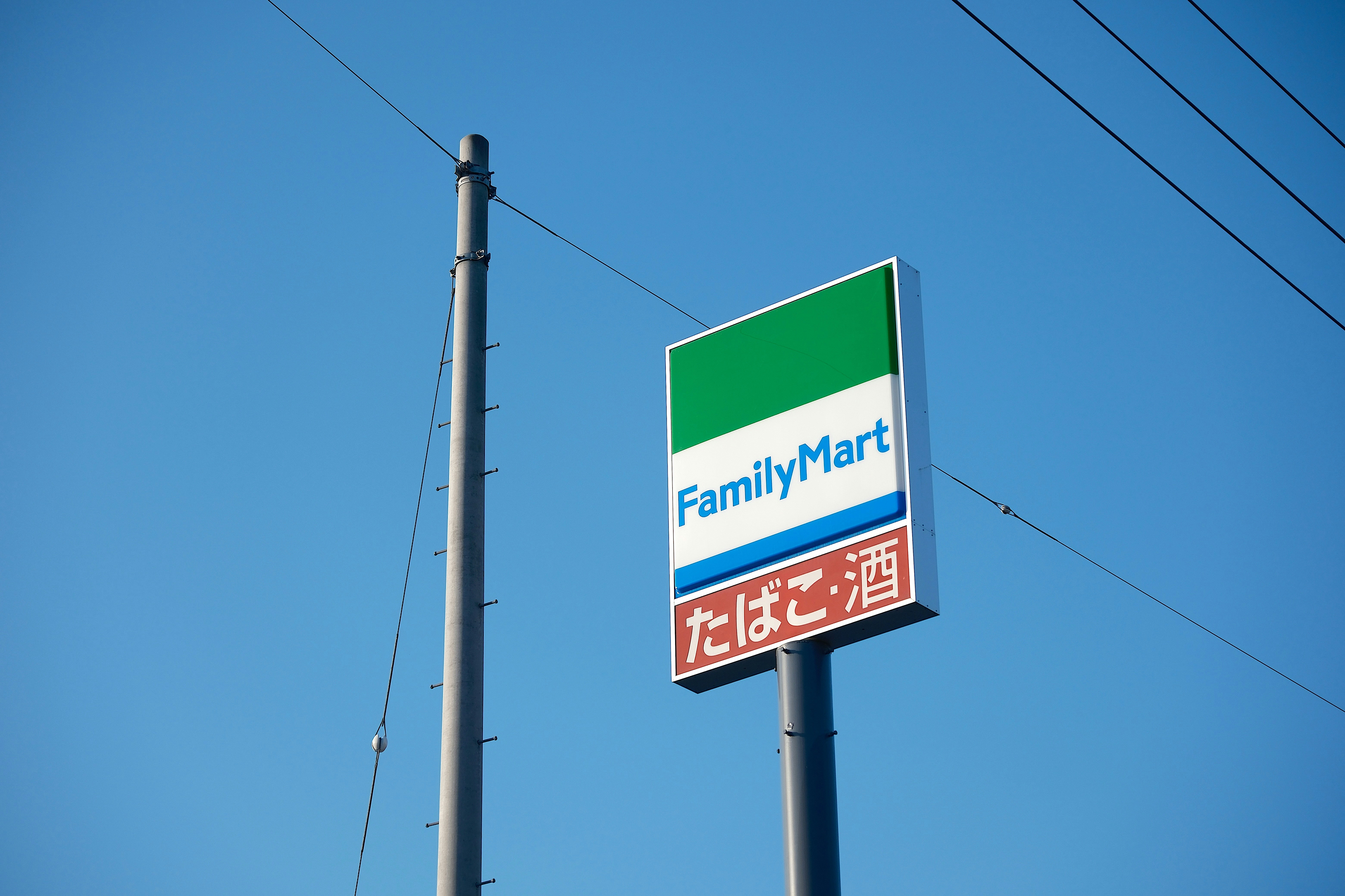 A familymart sign is displayed under a blue sky.