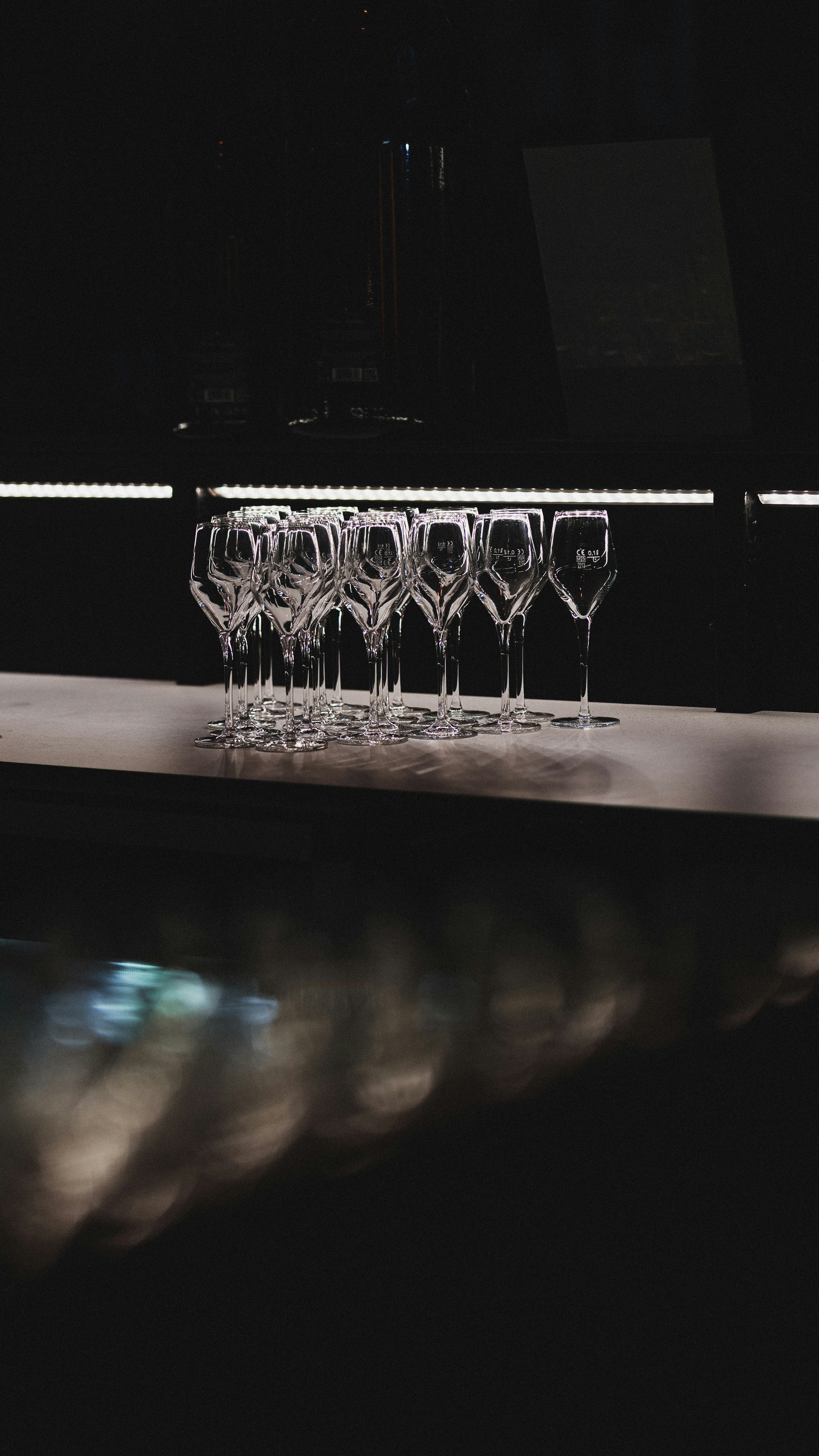 Champagne flutes line up in a dark environment.