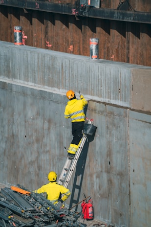 Construction workers are painting a concrete wall.