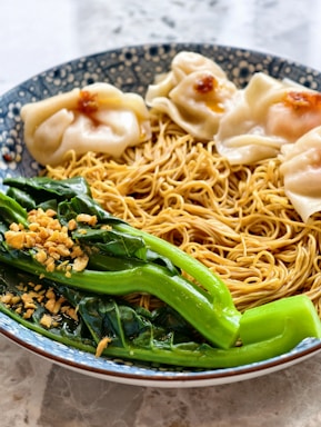 Noodles with dumplings and greens look delicious.