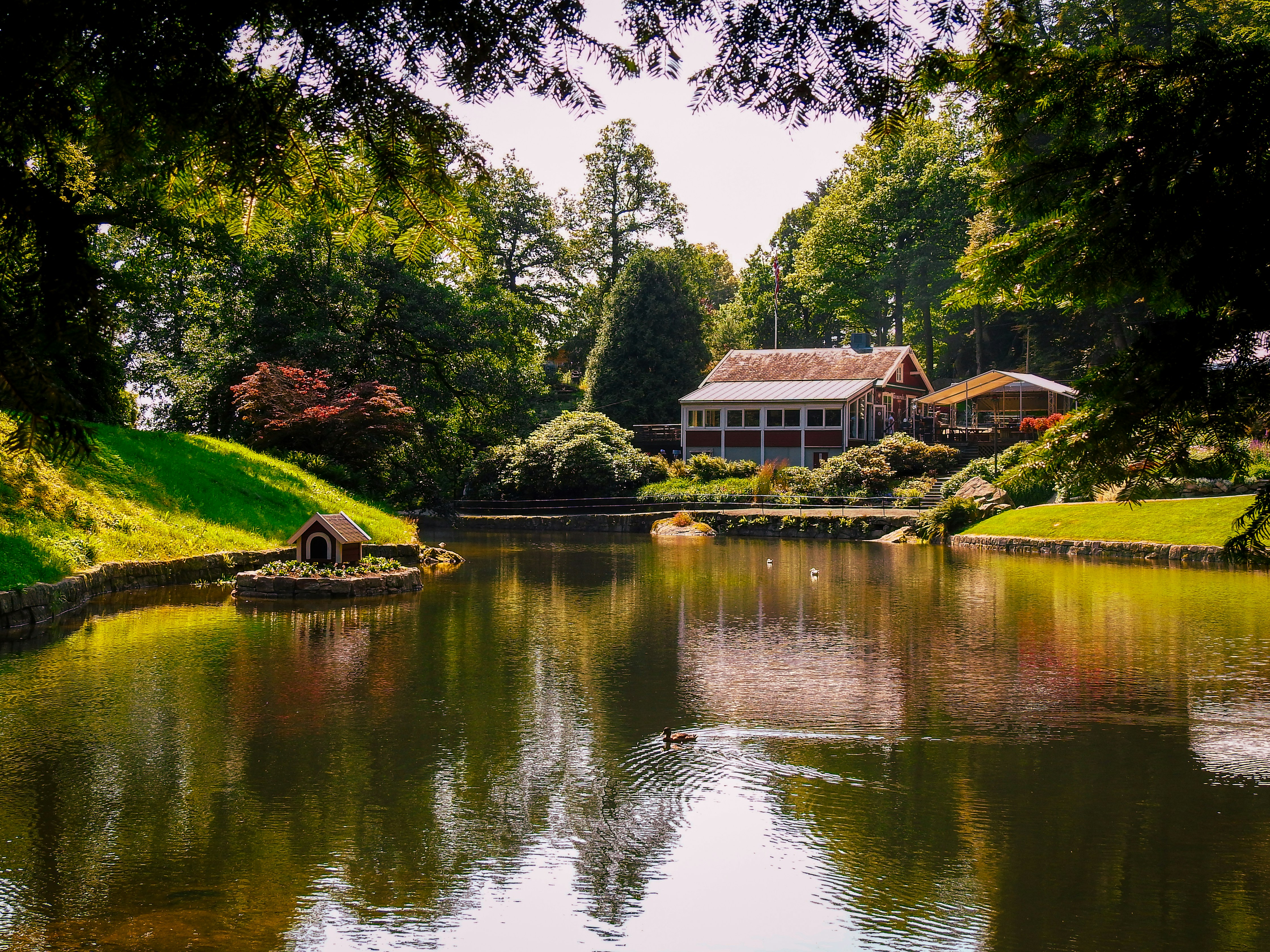 A tranquil lake reflects a beautiful house.