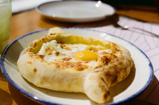 Khachapuri, a georgian bread dish, sits on a plate.