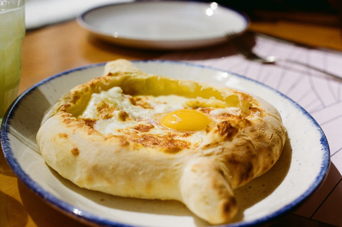 Adjarian khachapuri — the boat-shaped one, with butter and an egg yolk stirred through while it is still molten