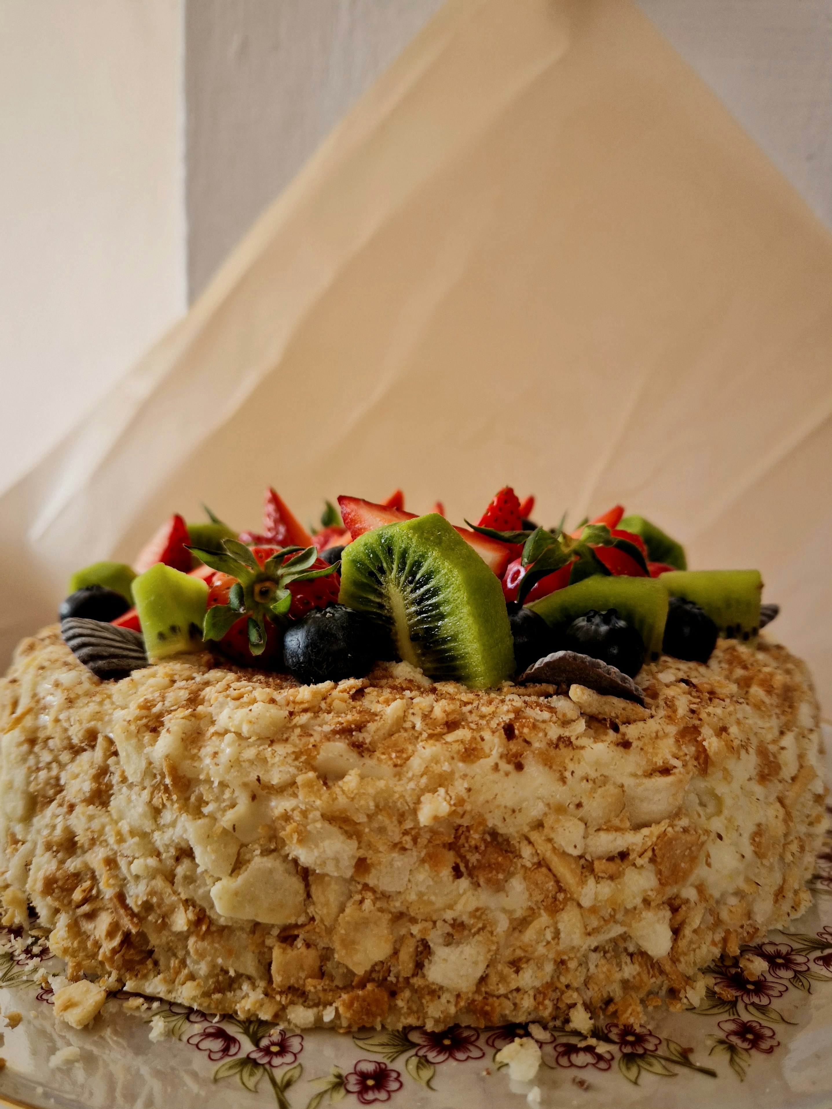 La torta ricoperta di frutta sembra deliziosa e appetitosa.