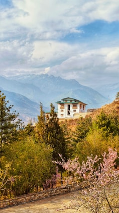 A house sits peacefully amid a mountainous landscape.
