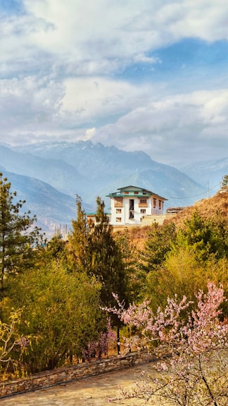 A house sits peacefully amid a mountainous landscape.