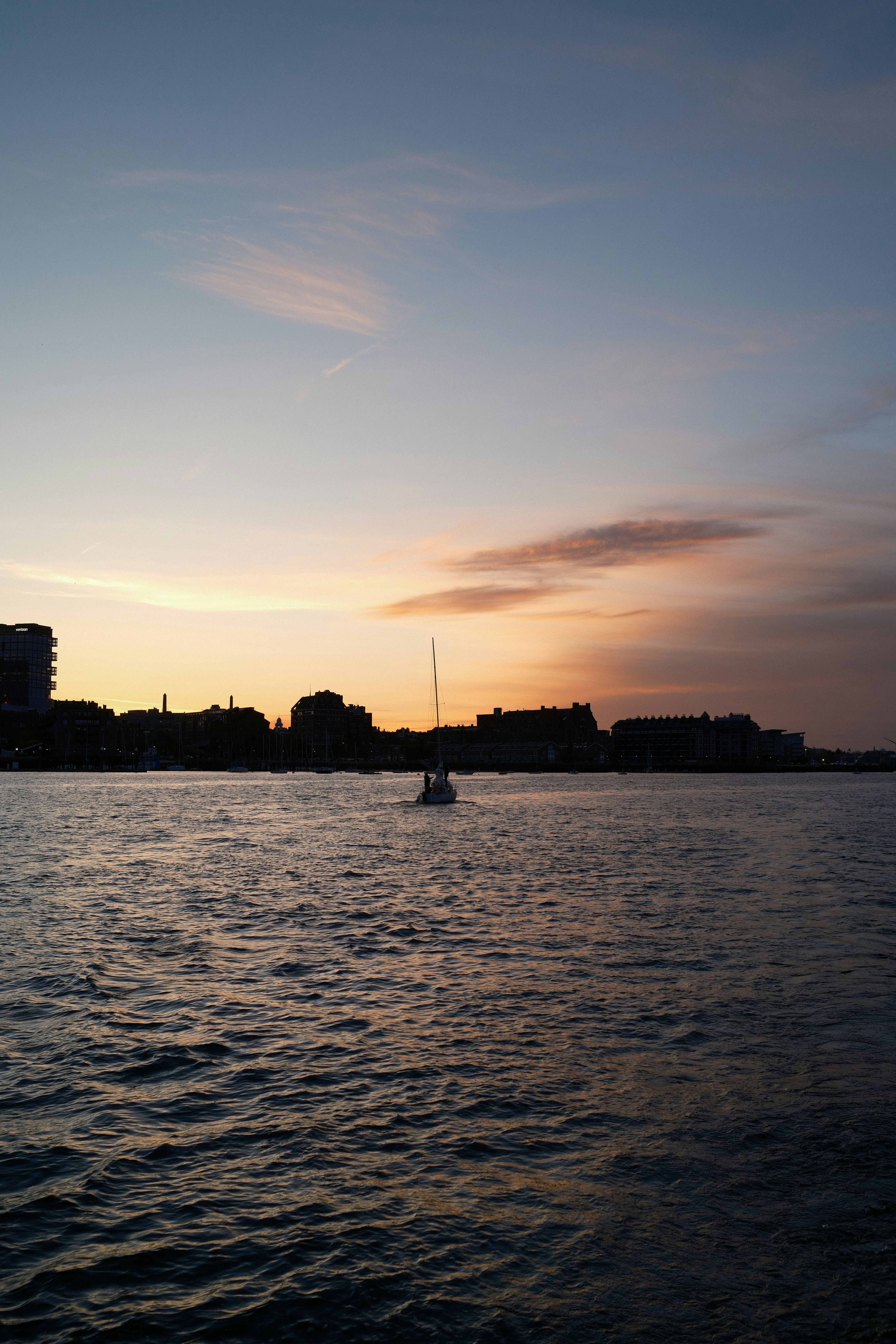 Sunset over water with a silhouette skyline.