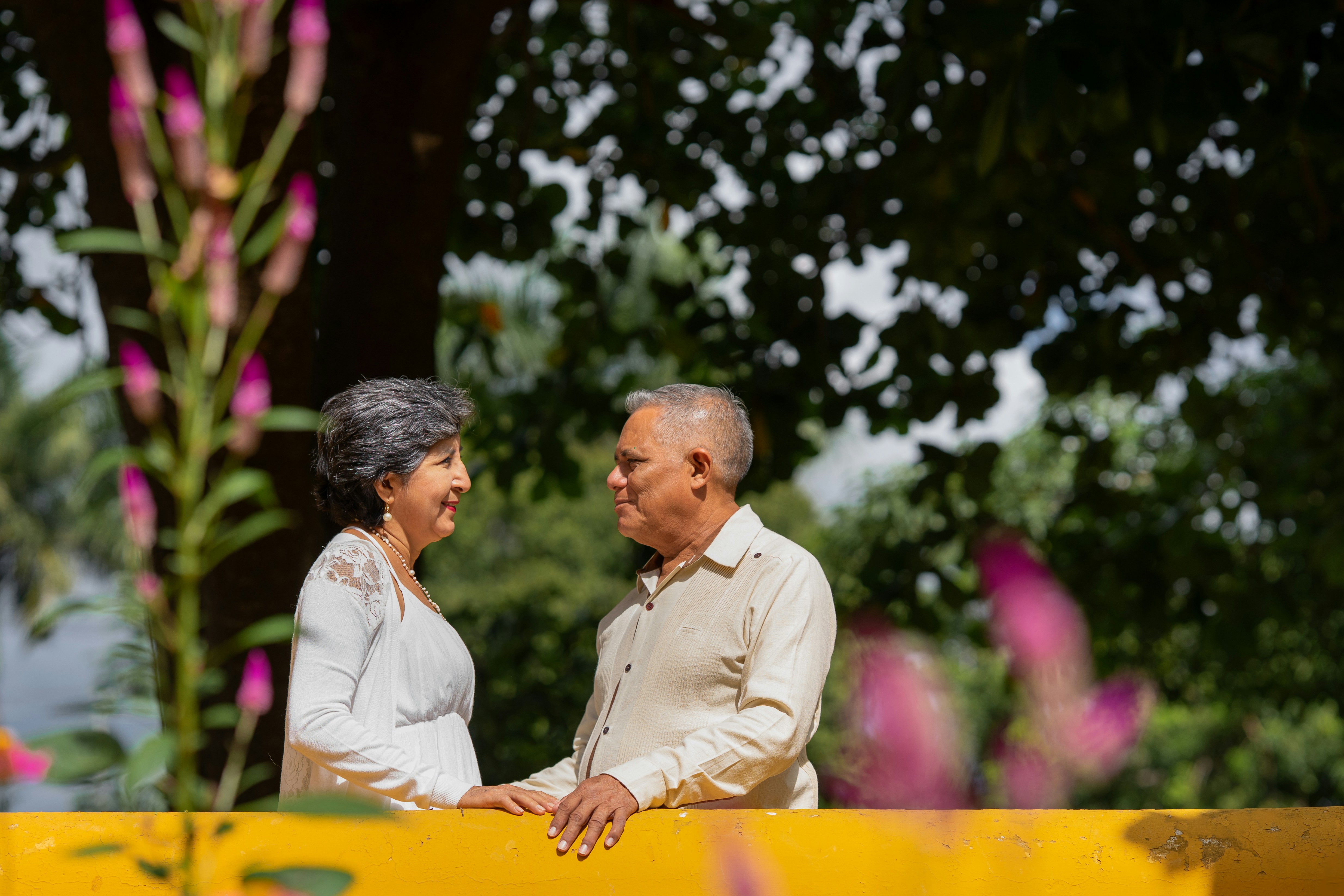 Happy elderly couple smiling at each other outdoors.