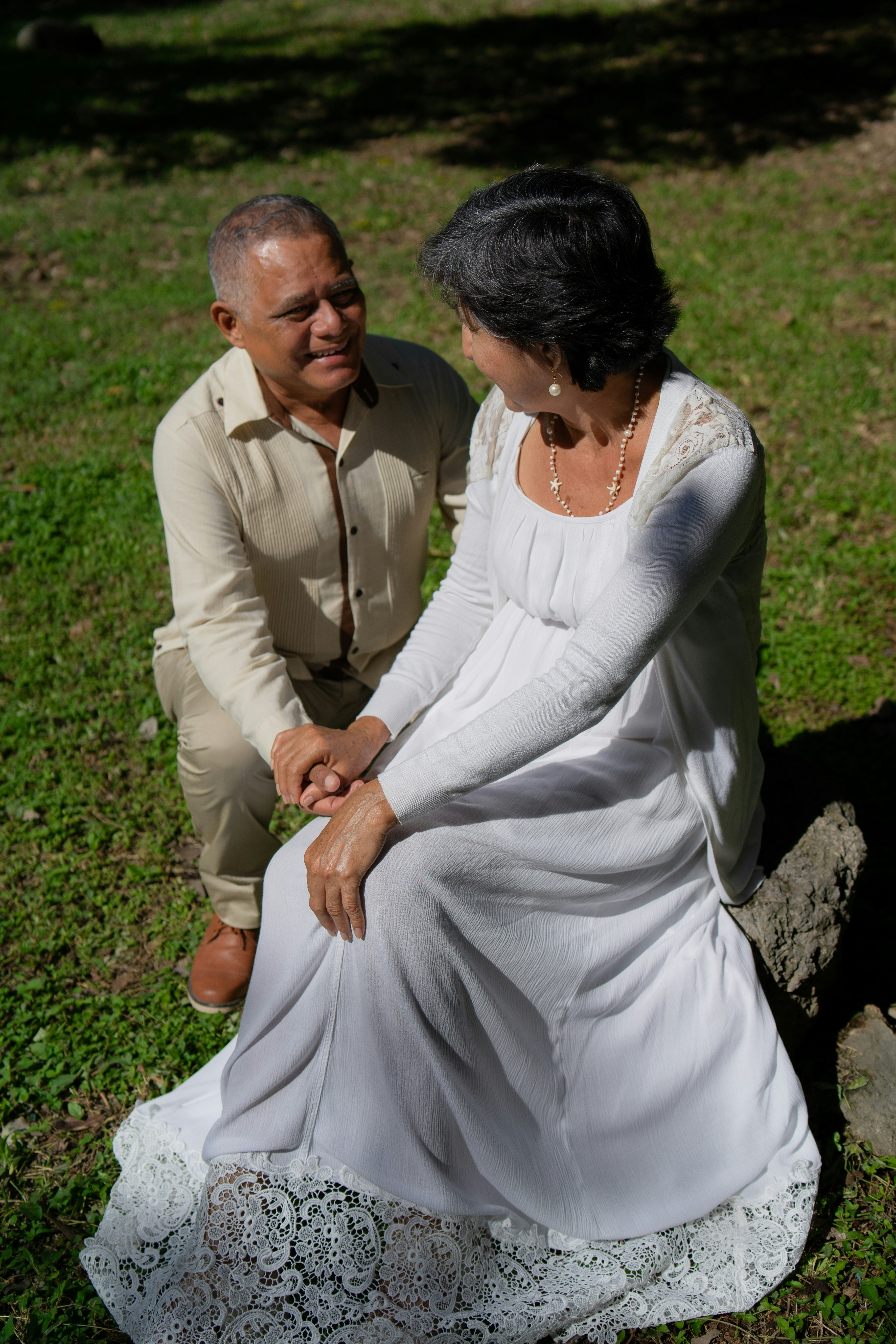 A couple is holding hands and smiling at each other.