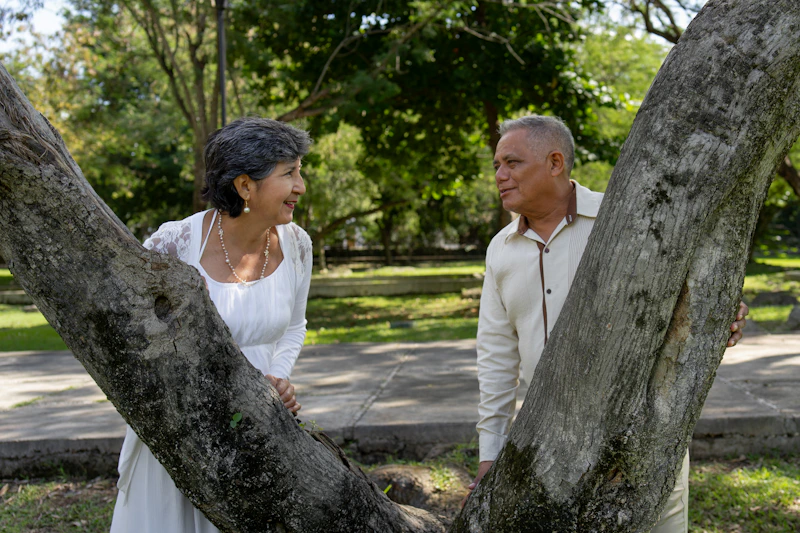 Couple smiling between two trees
