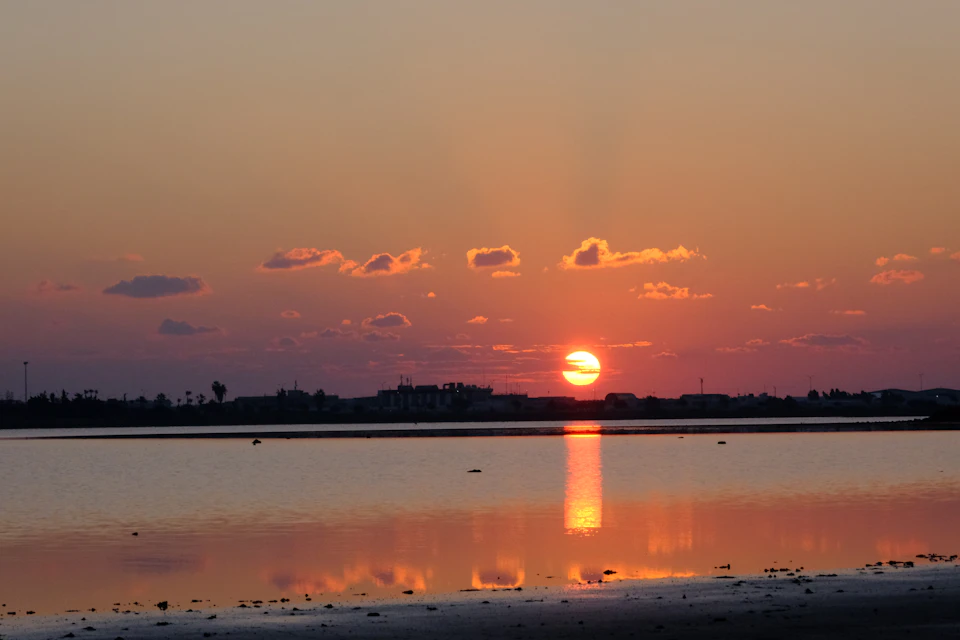 Sunset over calm waters with vibrant colors reflected in the serene lake