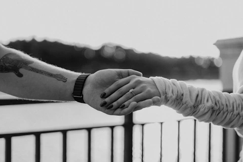 Couple holding hands, showing ring.