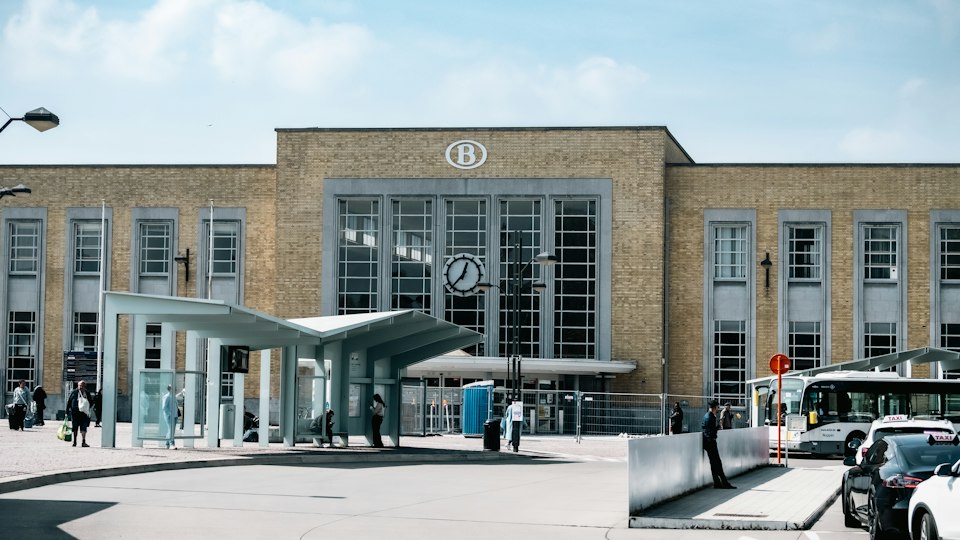 The facade of Bruges railway station under bright sunlight