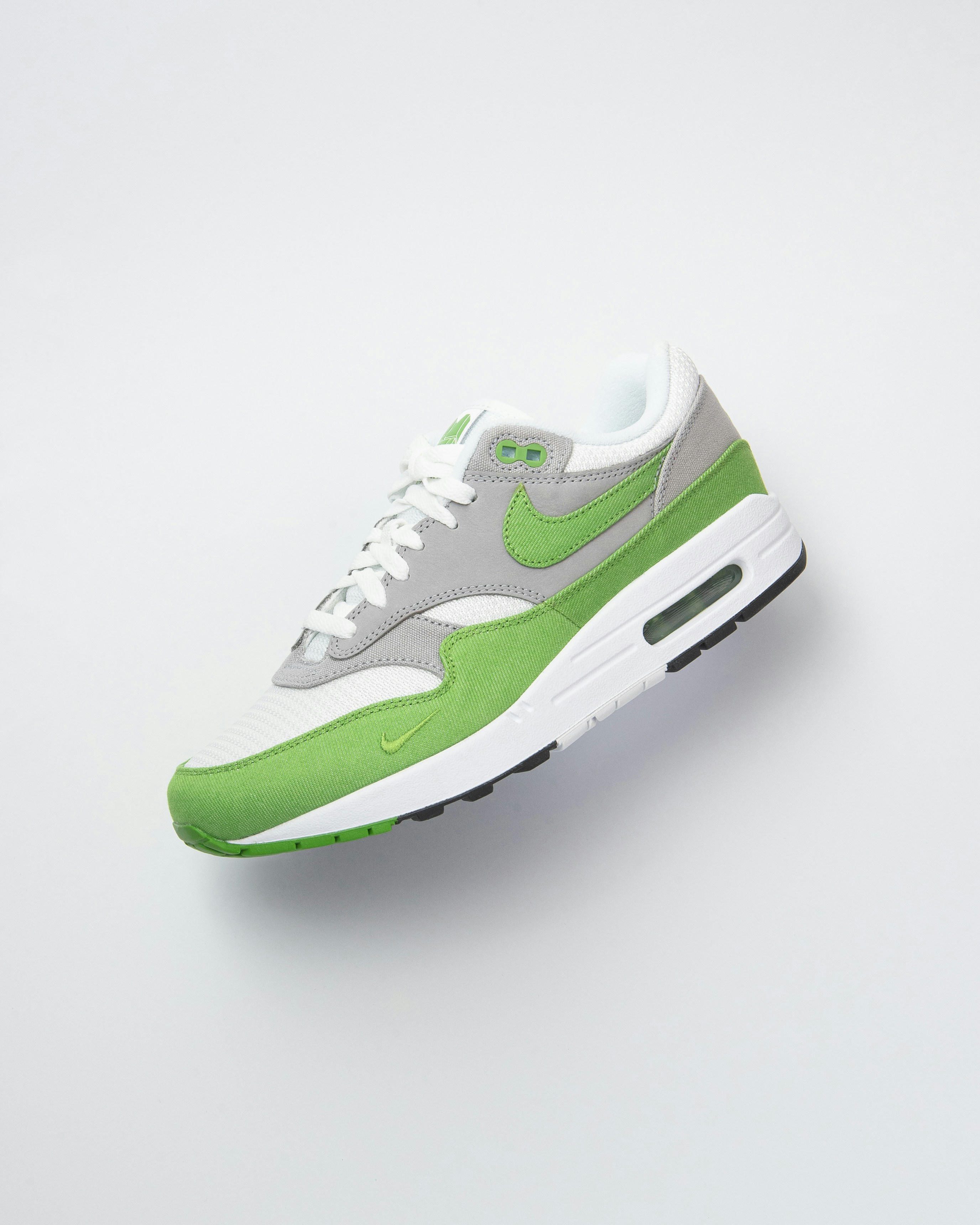 Sepatu kets nike air max hijau dan putih.