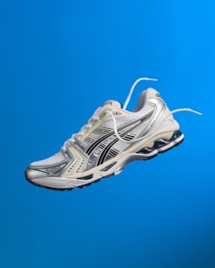 A white running shoe hovering in the air.