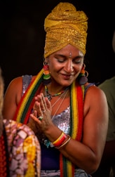 Woman wearing a turban and jewelry is praying.