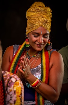 Woman wearing a turban and jewelry is praying.