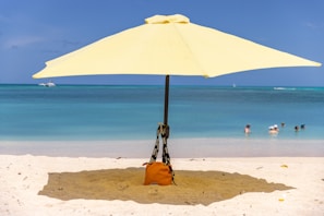 A yellow umbrella provides shade on the beach.