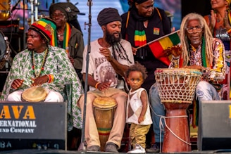 Musicians perform reggae music on stage with a child.