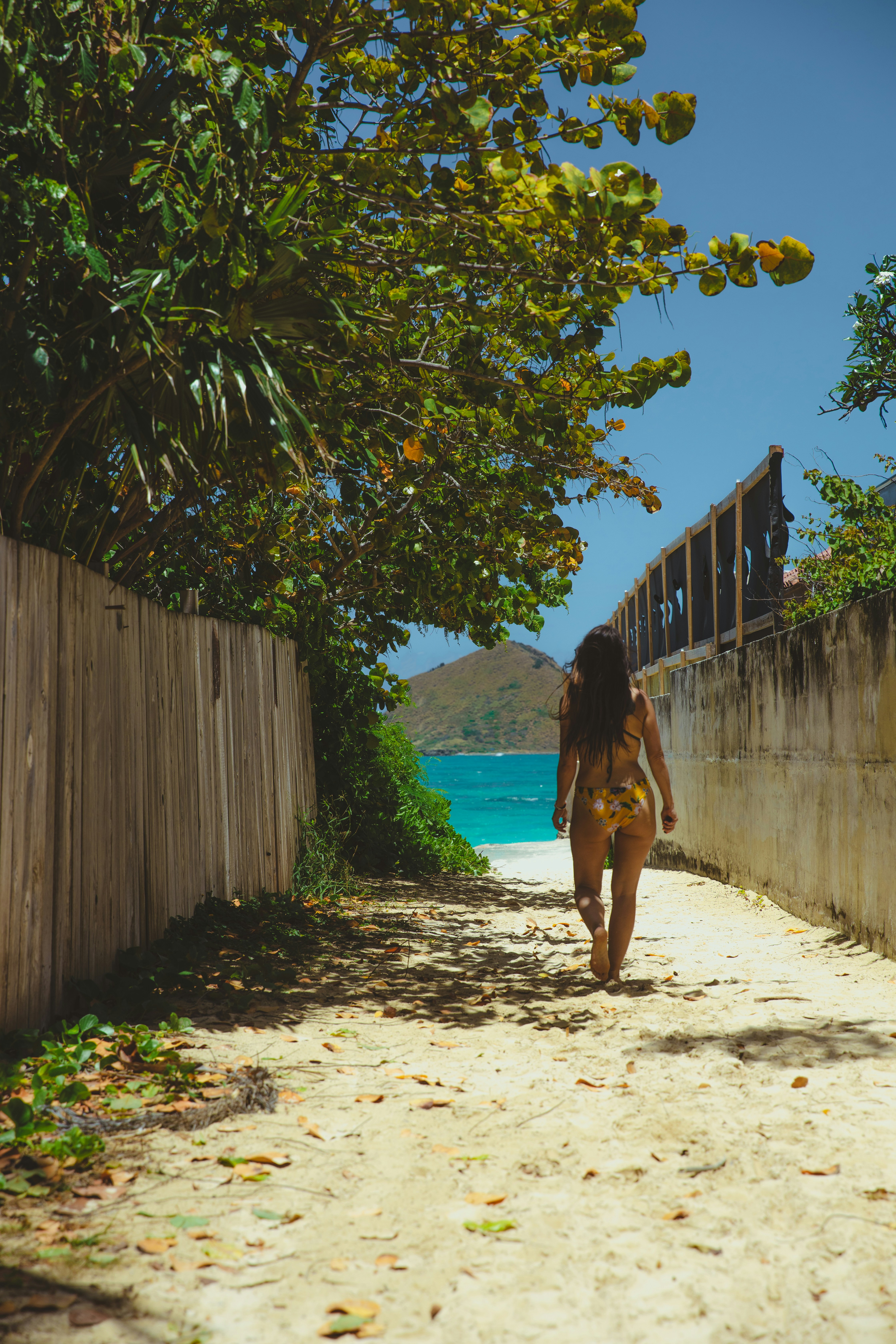 Eine Frau geht auf einen schönen Strand zu.