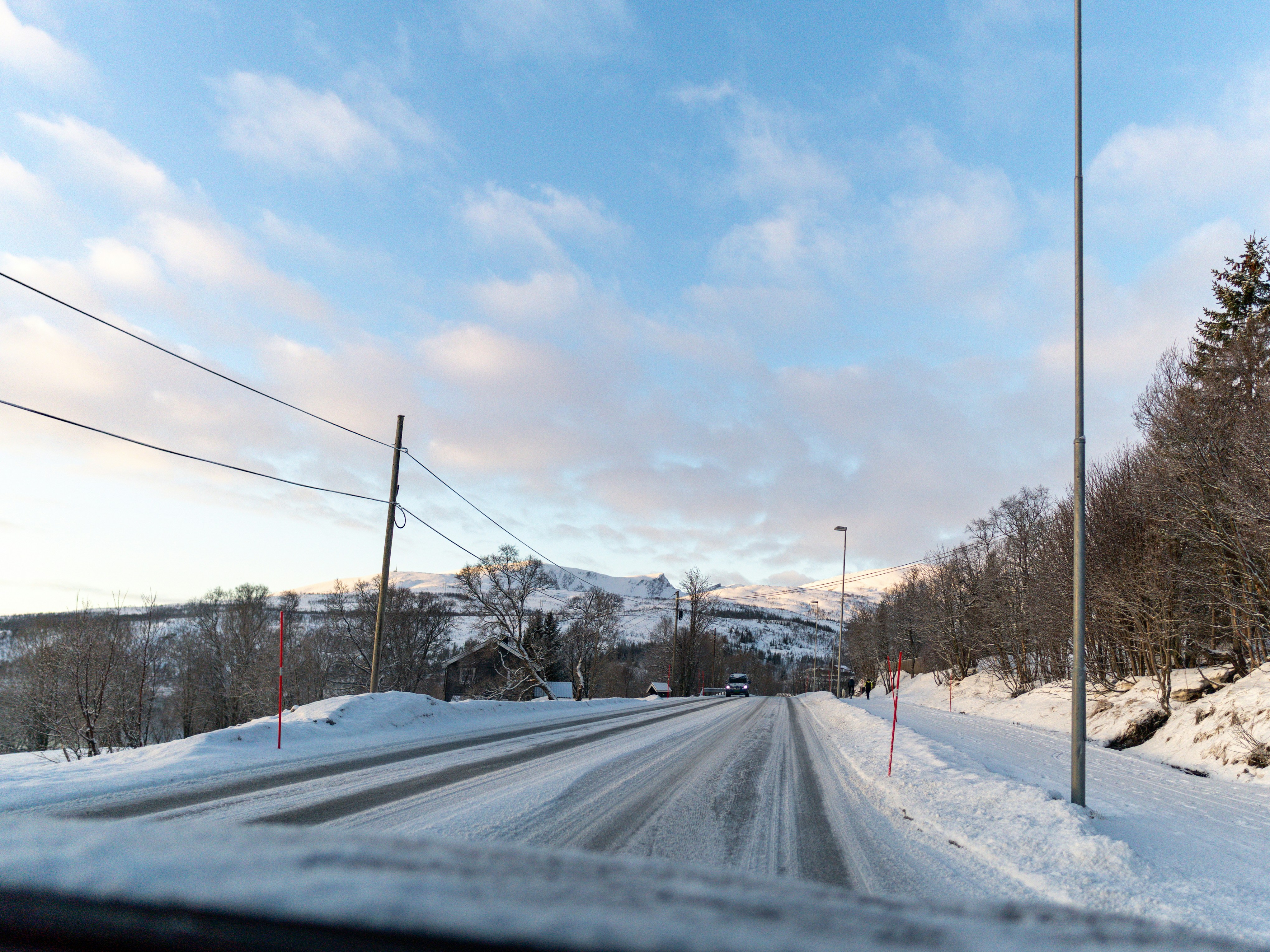 Snowy road through a wintery landscape.