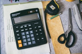 Calculator and office supplies on a desk.