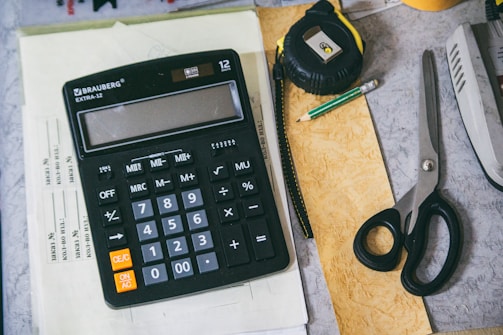 Calculator and office supplies on a desk.