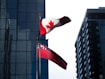 Canadian flags wave in front of buildings.